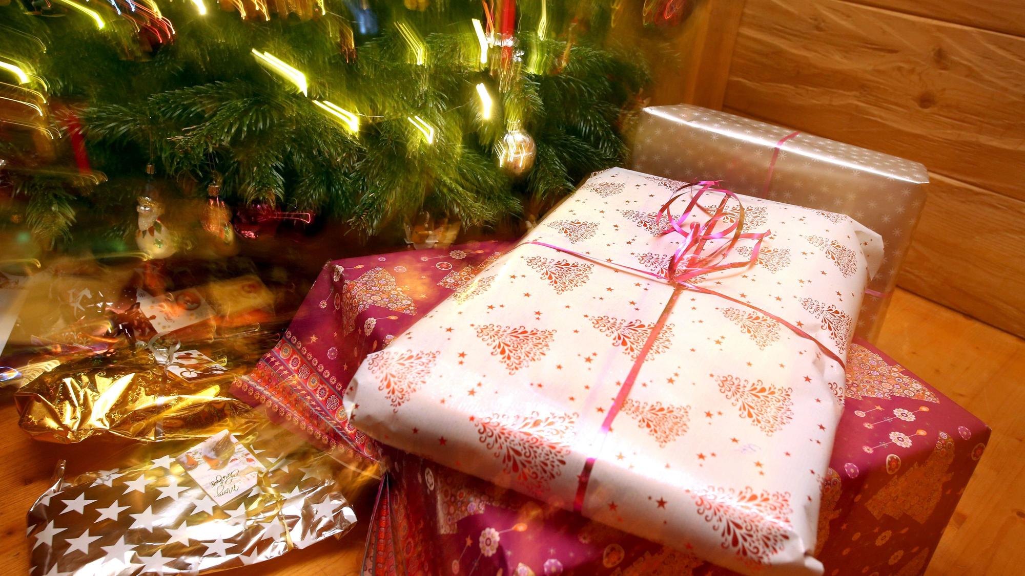 Weihnachtsgeschenke liegen unter einem geschmücktem Christbaum.