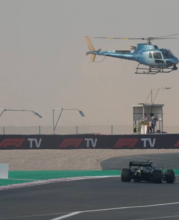 Ein TV-Hubschrauber fliegt über dem Rennwagen von Sebastian Vettel.