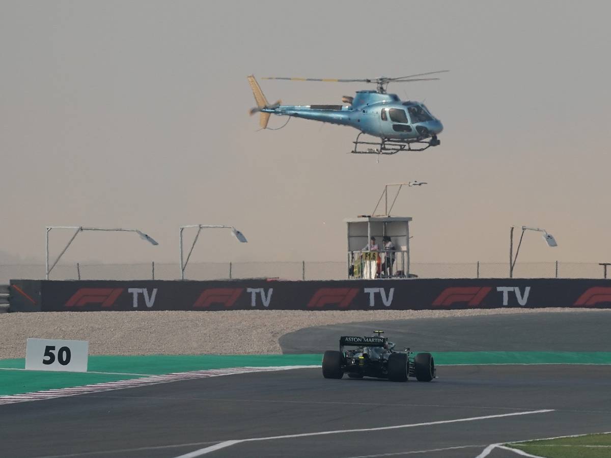 Ein TV-Hubschrauber fliegt über dem Rennwagen von Sebastian Vettel.