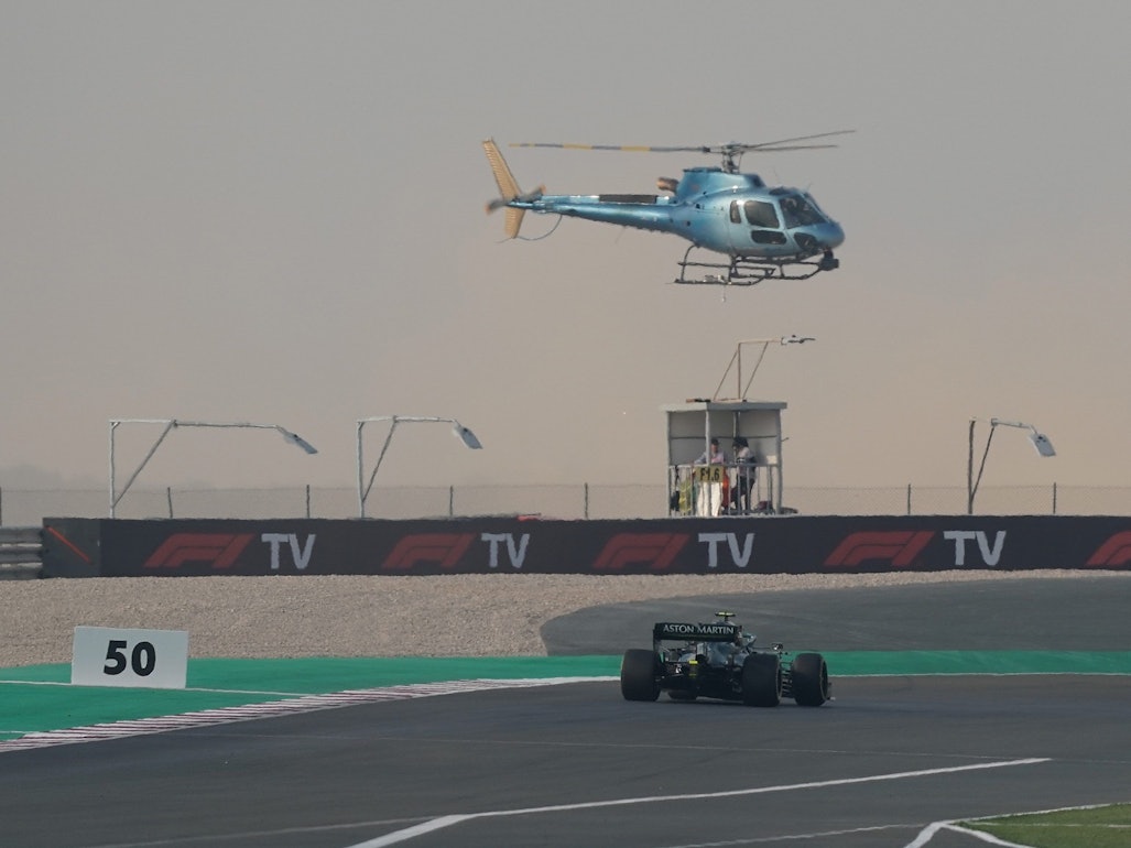 Ein TV-Hubschrauber fliegt über dem Rennwagen von Sebastian Vettel.