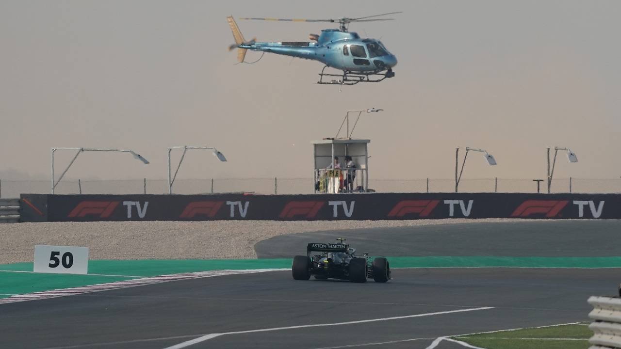 Ein TV-Hubschrauber fliegt über dem Rennwagen von Sebastian Vettel.