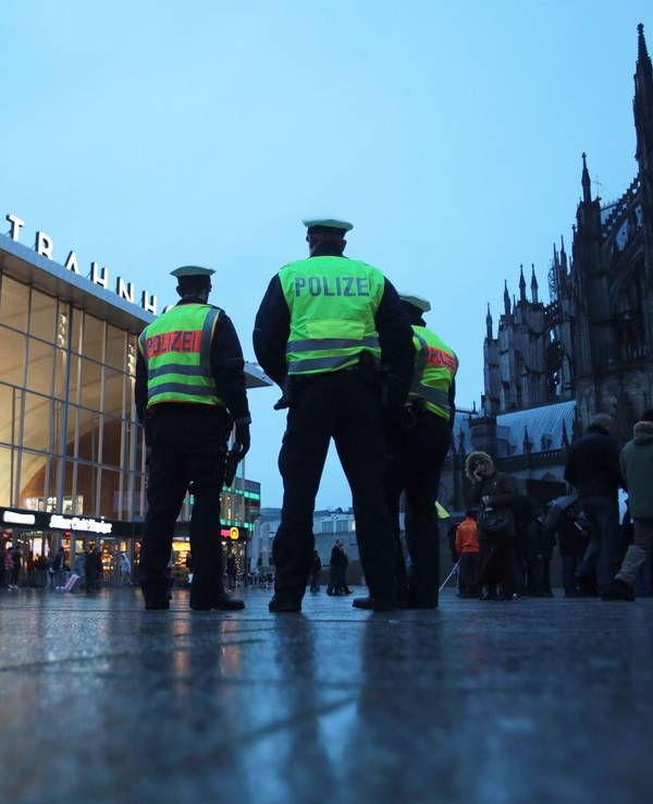 Drei Polizisten stehen in Köln vor dem Hauptbahnhof.