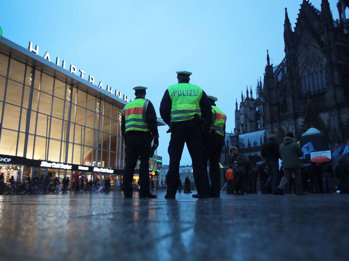 Drei Polizisten stehen in Köln vor dem Hauptbahnhof.