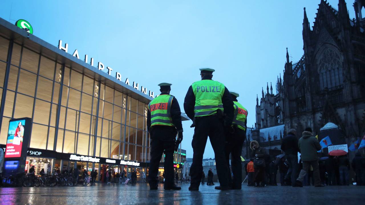 Drei Polizisten stehen in Köln vor dem Hauptbahnhof.