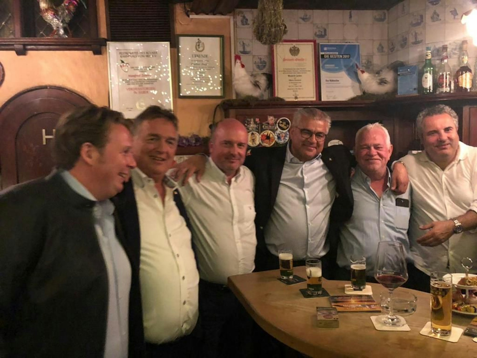 Präsidenten stehen Arm in Arm an der Theke
