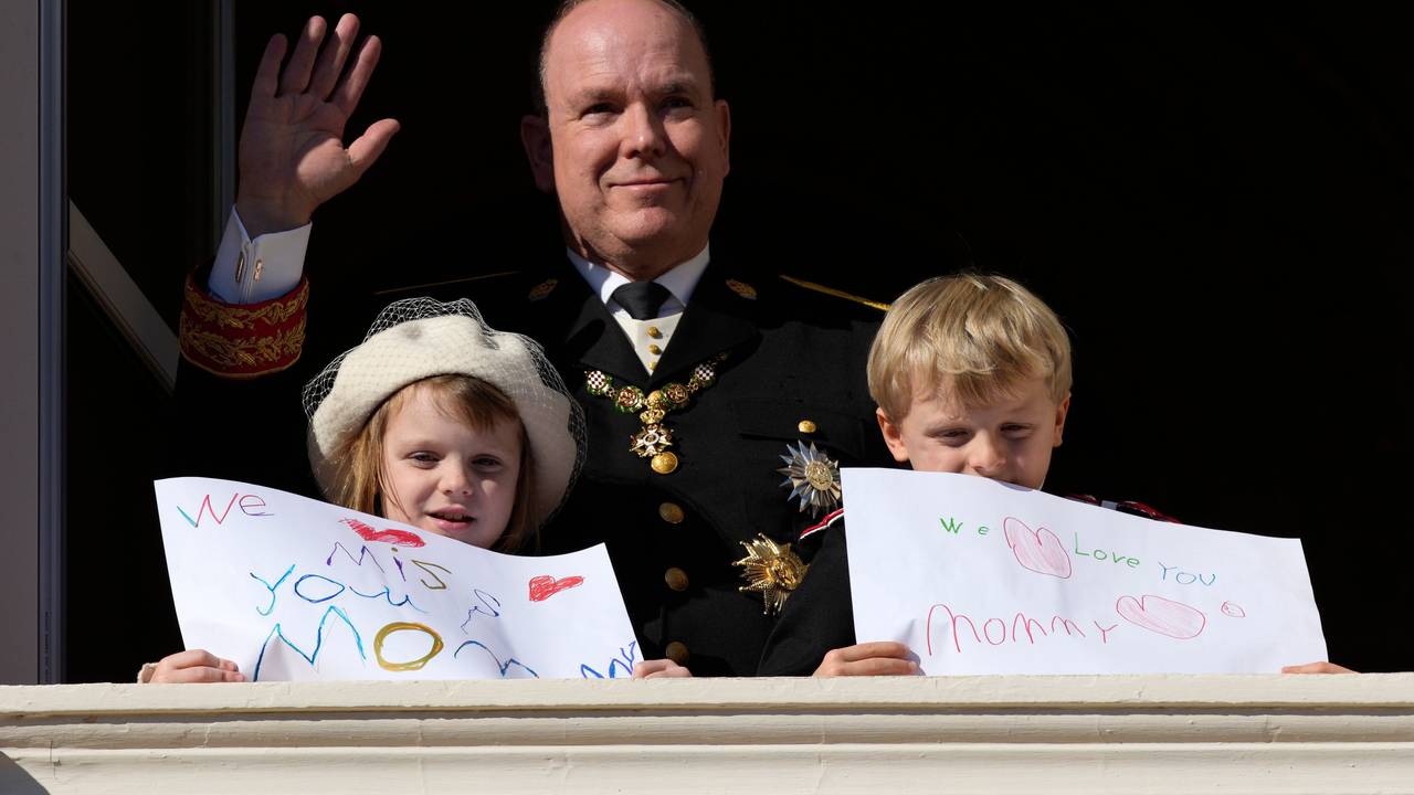 Fürst Albert II. von Monaco (M) winkt während der Feierlichkeiten zum Nationalfeiertag vom Balkon des Palastes von Monaco, während seine Kinder Fürst Jacques und Prinzessin Gabriella von Monaco Bilder mit Botschaften für ihre Mutter Fürstin Charlène in der Hand halten.