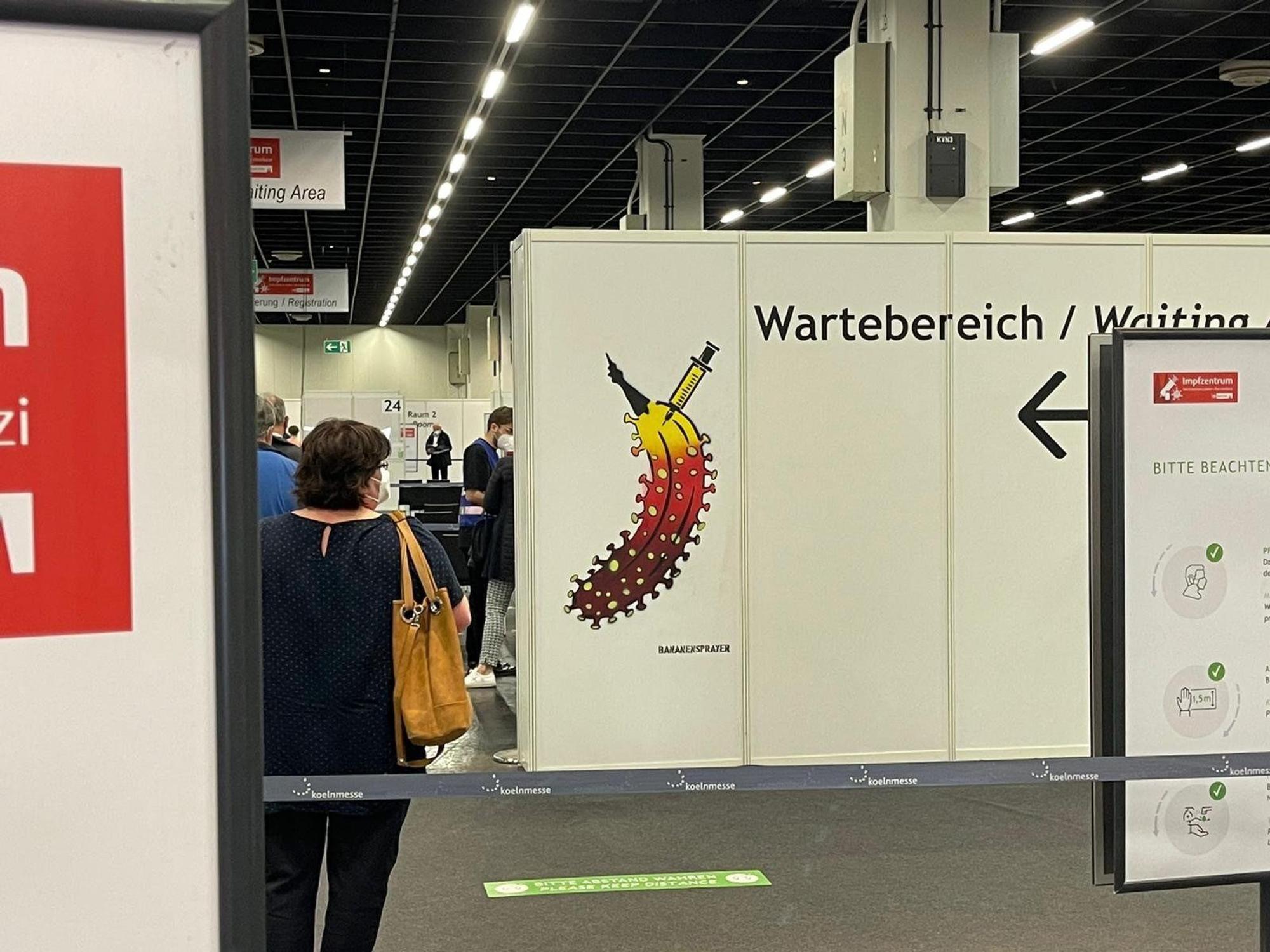 Eine Trennwand steht in einer Halle, auf der eine Banane zu sehen ist.