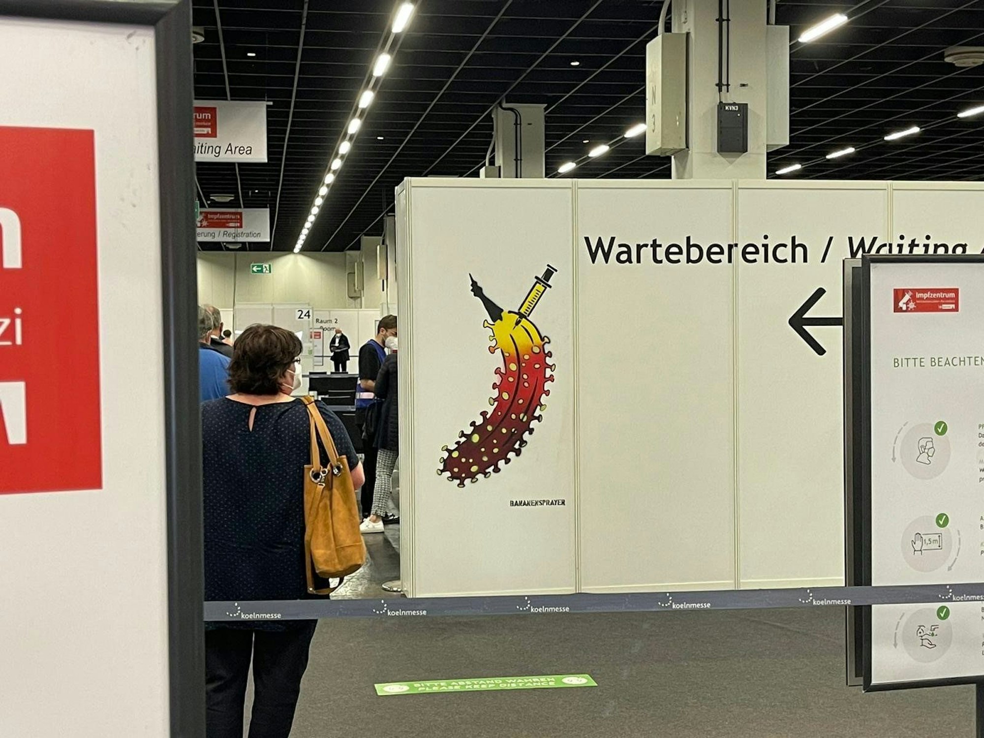 Eine Trennwand steht in einer Halle, auf der eine Banane zu sehen ist.