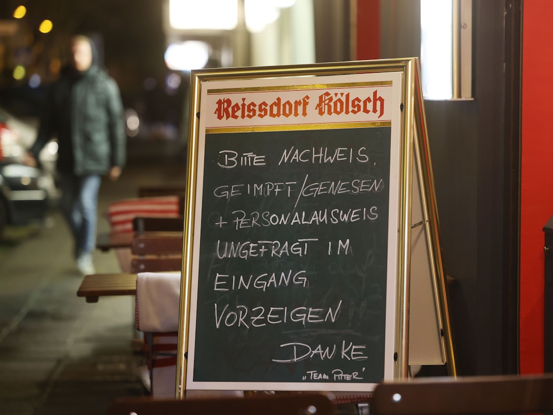 Köln: Ein Schild, das auf die 2G-Regel hinweist, steht vor einer Gaststätte.