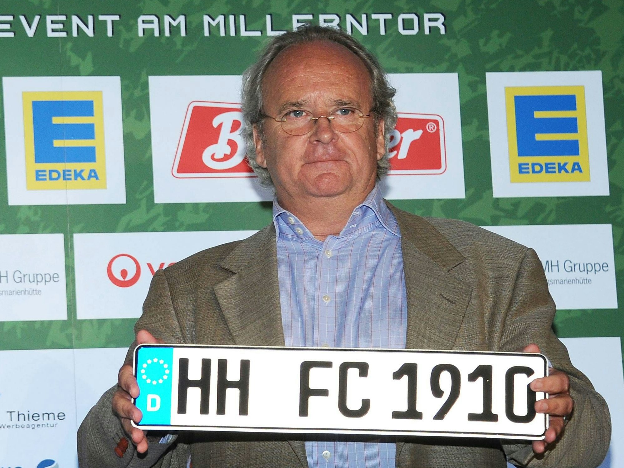 Reinhold Beckmann (Initiator NestWerk und Tag der Legenden) und Christian Hinzpeter (Vorstand NESTWERK e.V) und das zu versteigernde Nummernschild (FC-St. Pauli Gründungsjahr).