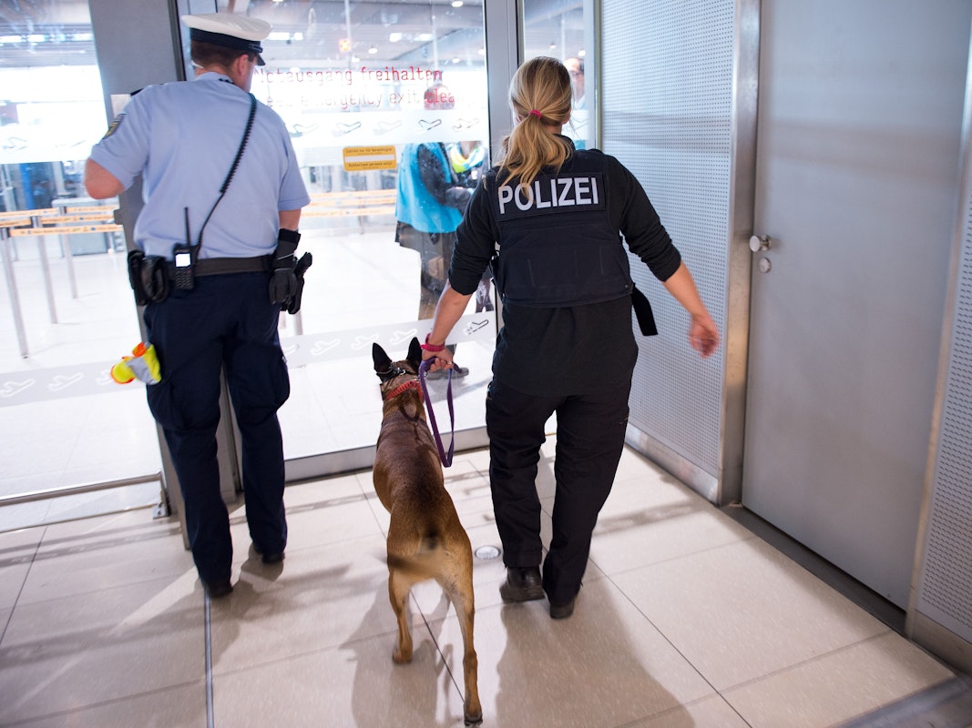 Polizisten mit einem Hund betreten 30.05.2016 den Sicherheitsbereich im Terminal 1 am Flughafen Köln/Bonn (Nordrhein-Westfalen).