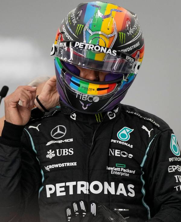 Lewis Hamilton steht in Rennmontur in der Box.
