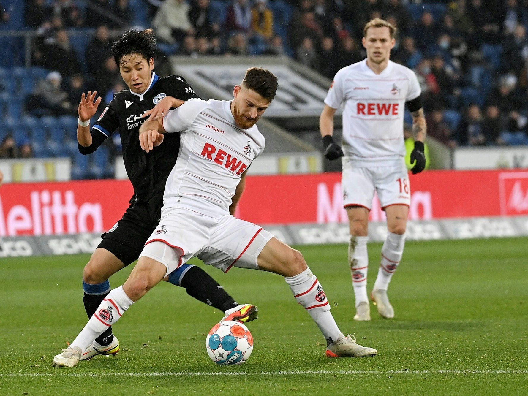 Einer der stärksten Kölner in Bielefeld: Torschütze Salih Özcan (Mitte) im Duell mit Arminia Assistgeber Masaya Okugawa (links) am 4. Dezember 2021.