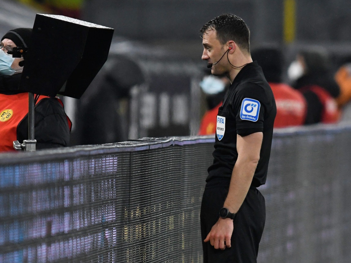 Schiedsrichter Felix Zwayer betrachtet in der Review Area eine Szene beim Spiel zwischen Borussia Dortmund und dem FC Bayern.