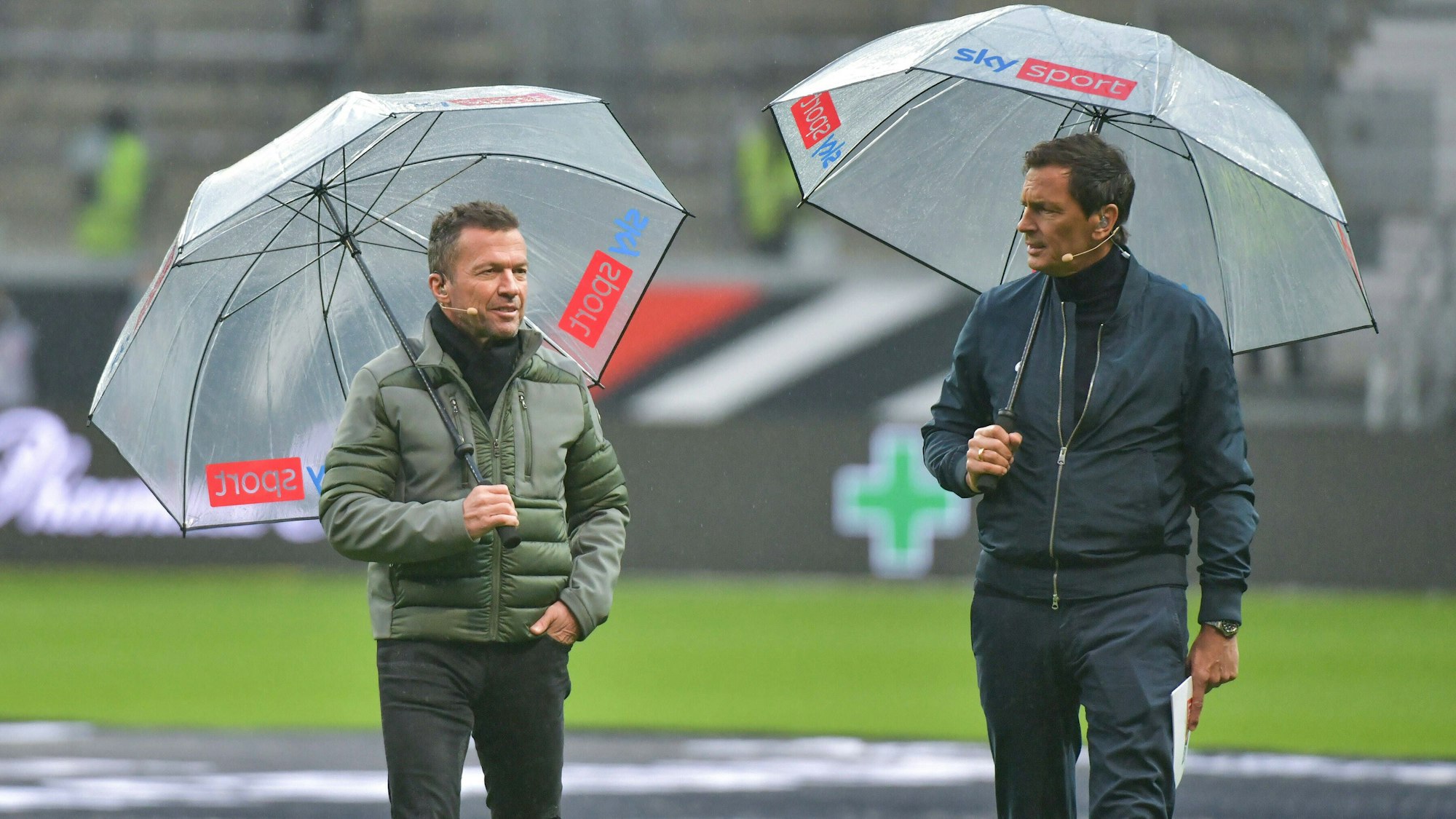 Sky-Experte Lothar Matthäus und -Moderator Sebastian Hellmann gehen über den Platz.