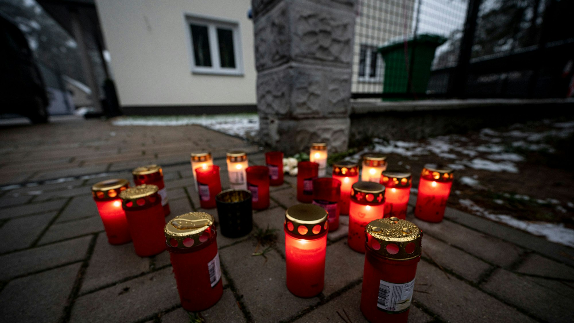 Vor dem Einfamilienhaus in Senzig, einem Ortsteil der Stadt Königs Wusterhausen im Landkreis Dahme-Spreewald, stehen Kerzen. Die Polizei hat dort fünf Tote in einem Wohnhaus gefunden. Die Polizei geht von einem Tötungsverbrechen aus, sagte ein Sprecher.