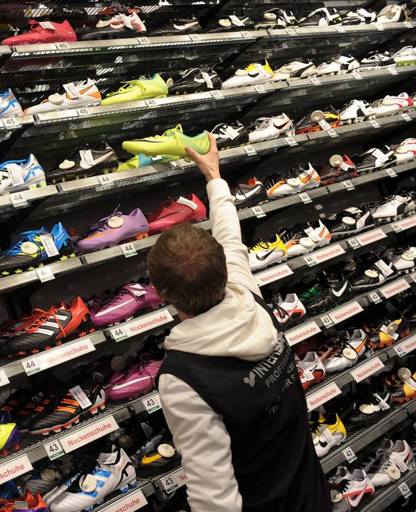 Verkäufer Michael Engel sucht am 27.12.2011 in einer Intersport-Filiale in Bamberg (Oberfranken) für einen Kunden ein Paar Fußballschuhe.