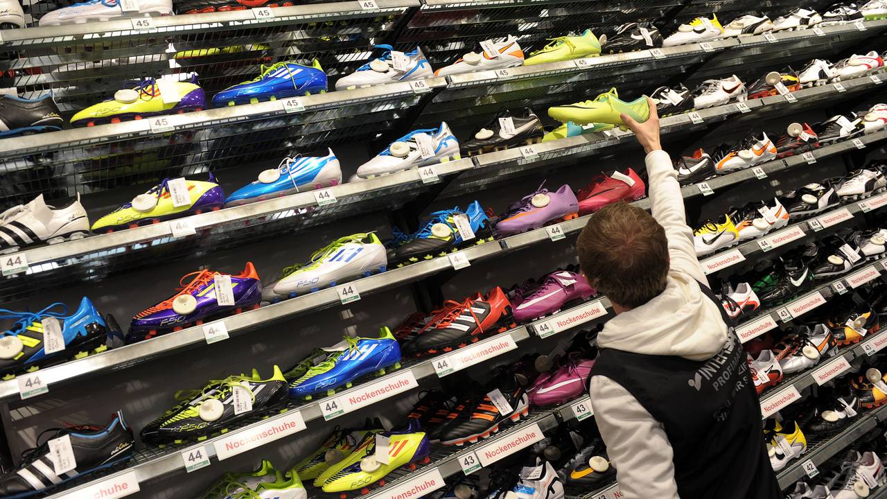 Verkäufer Michael Engel sucht am 27.12.2011 in einer Intersport-Filiale in Bamberg (Oberfranken) für einen Kunden ein Paar Fußballschuhe.