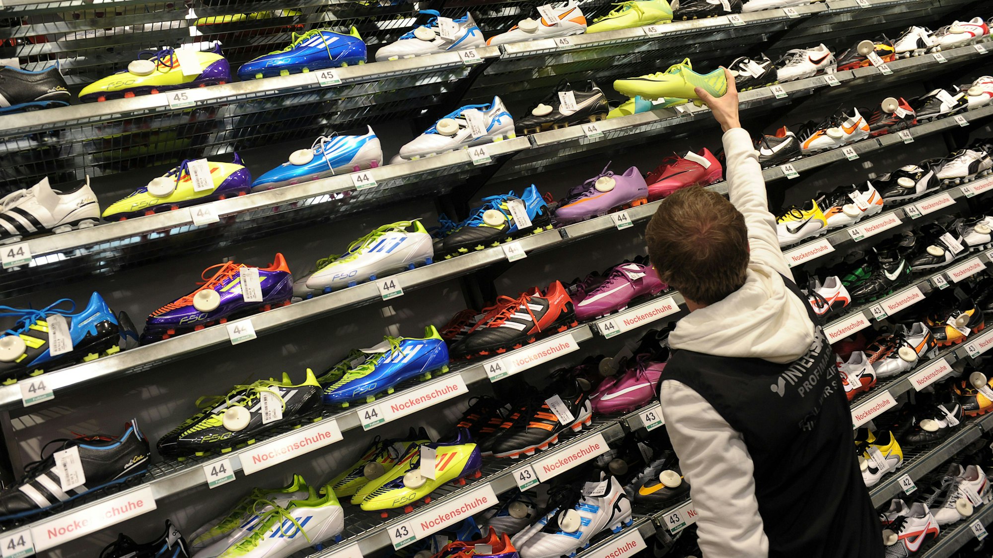 Verkäufer Michael Engel sucht am 27.12.2011 in einer Intersport-Filiale in Bamberg (Oberfranken) für einen Kunden ein Paar Fußballschuhe.