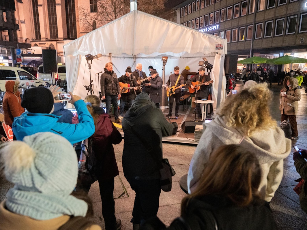 Menschen stehen bei einer Mahnwache gegen Obdachlosigkeit.