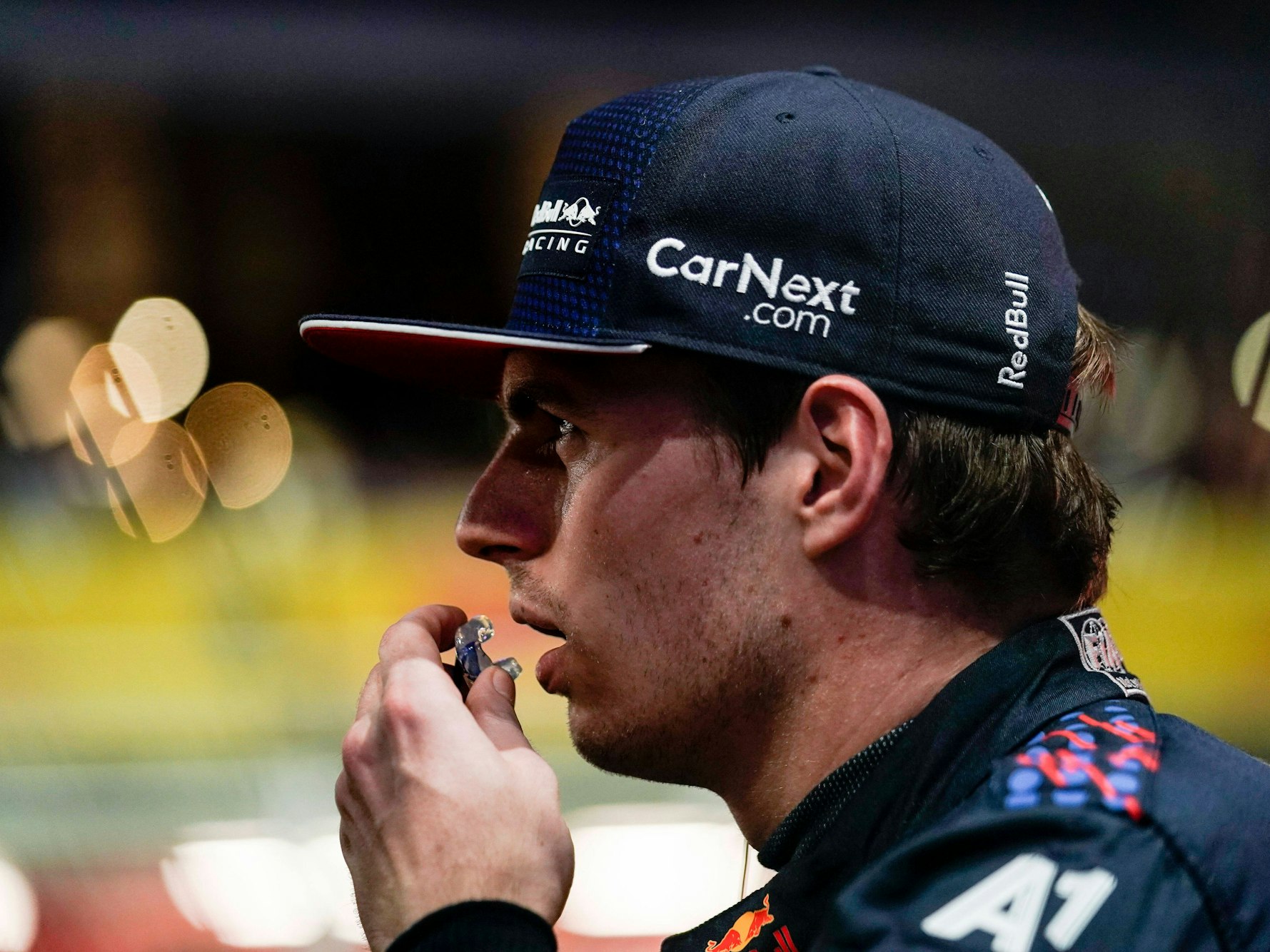 Max Verstappen trägt eine Kappe und schaut mit geöffnetem Mund zur Seite.