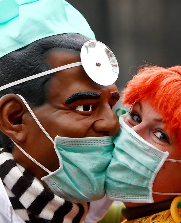 Zwei Narren "bützen" (küssen) sich am Mittwoch (11.11.2009) in Köln aus Angst vor einer Ansteckung mit der Schweingrippe mit Schutzmasken. Schlag 11 Uhr 11 hat in den rheinischen Karnevalshochburgen die fünfte Jahreszeit begonnen.