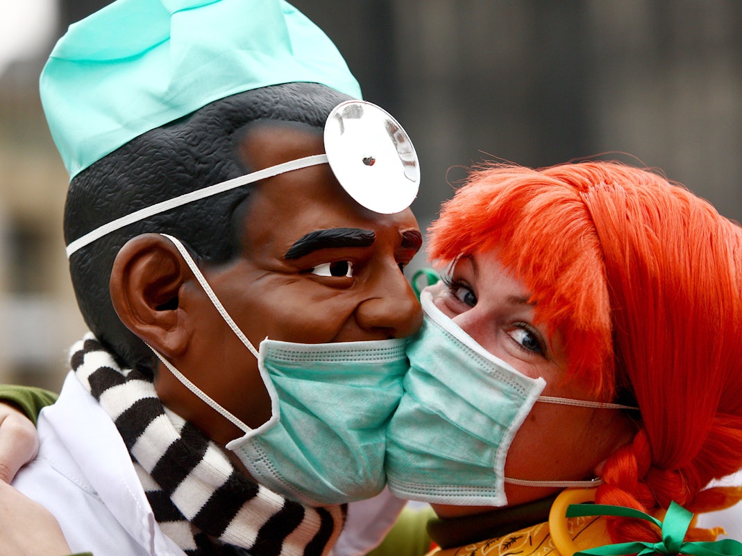 Zwei Narren "bützen" (küssen) sich am Mittwoch (11.11.2009) in Köln aus Angst vor einer Ansteckung mit der Schweingrippe mit Schutzmasken. Schlag 11 Uhr 11 hat in den rheinischen Karnevalshochburgen die fünfte Jahreszeit begonnen.