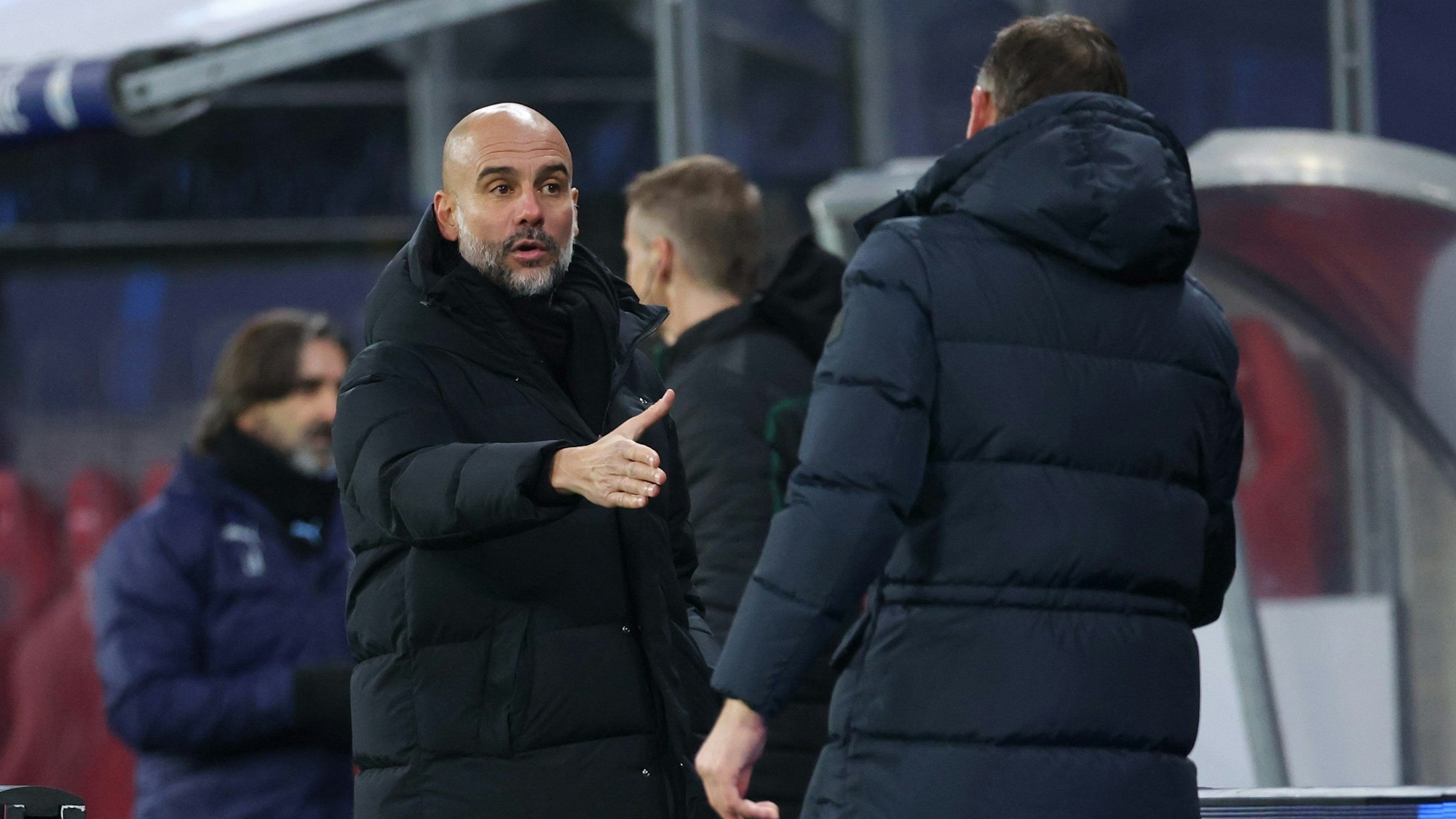 Manchesters Trainer Pep Guardiola (l) reicht nach dem Spiel Leipzigs Interimstrainer Achim Beierlorzer die Hand.