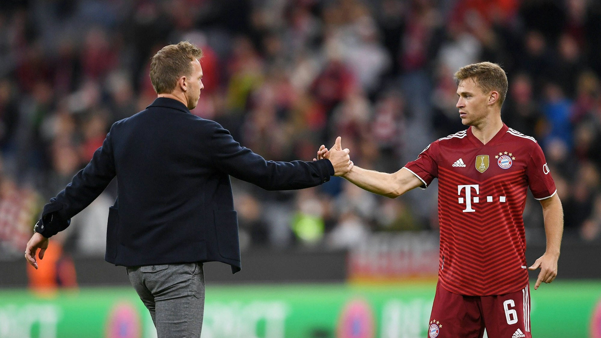 Joshua Kimmich und Julian Nagelsmann geben sich die Hände.