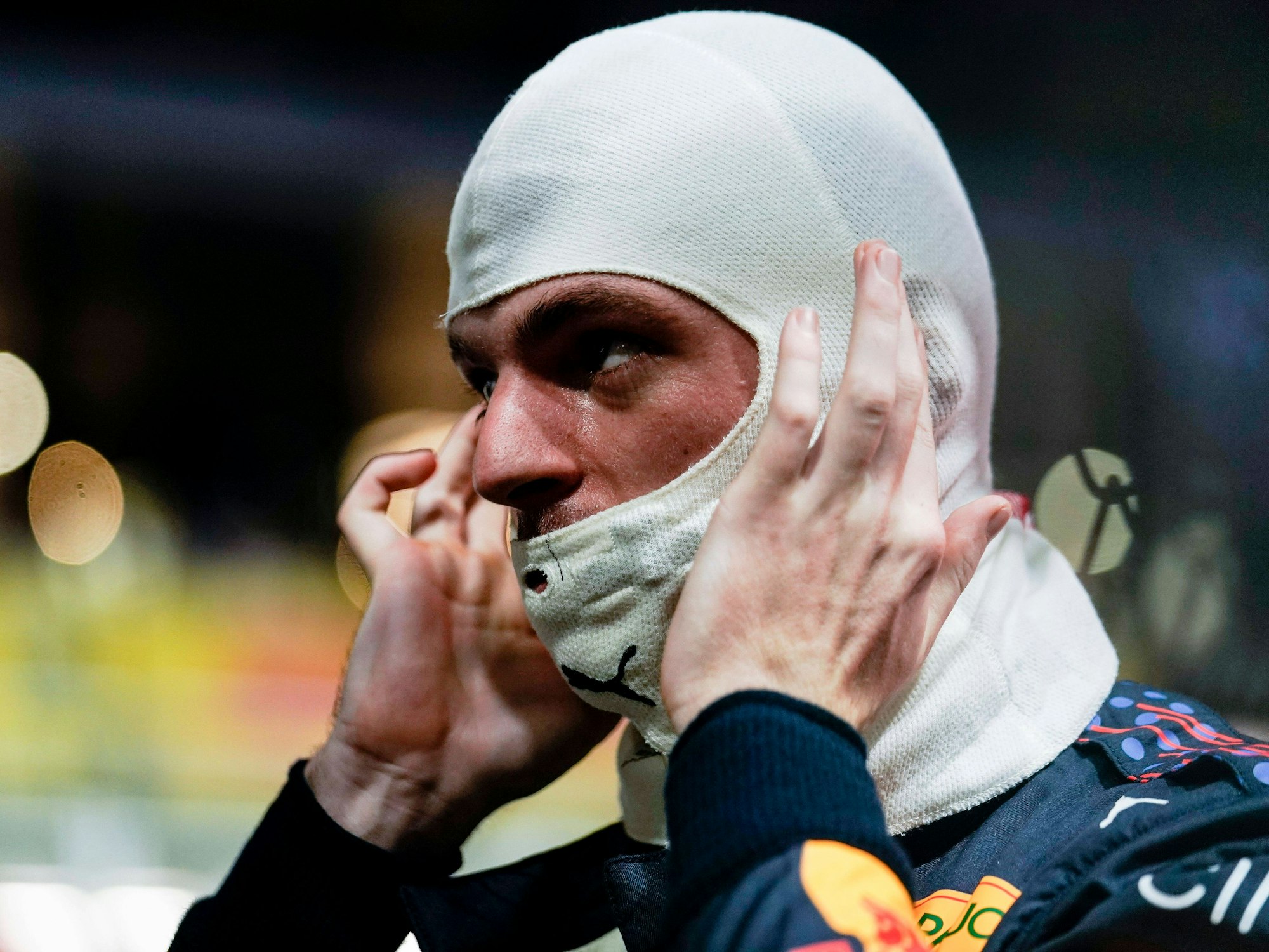Max Verstappen trägt eine Feuerschutzhaube.