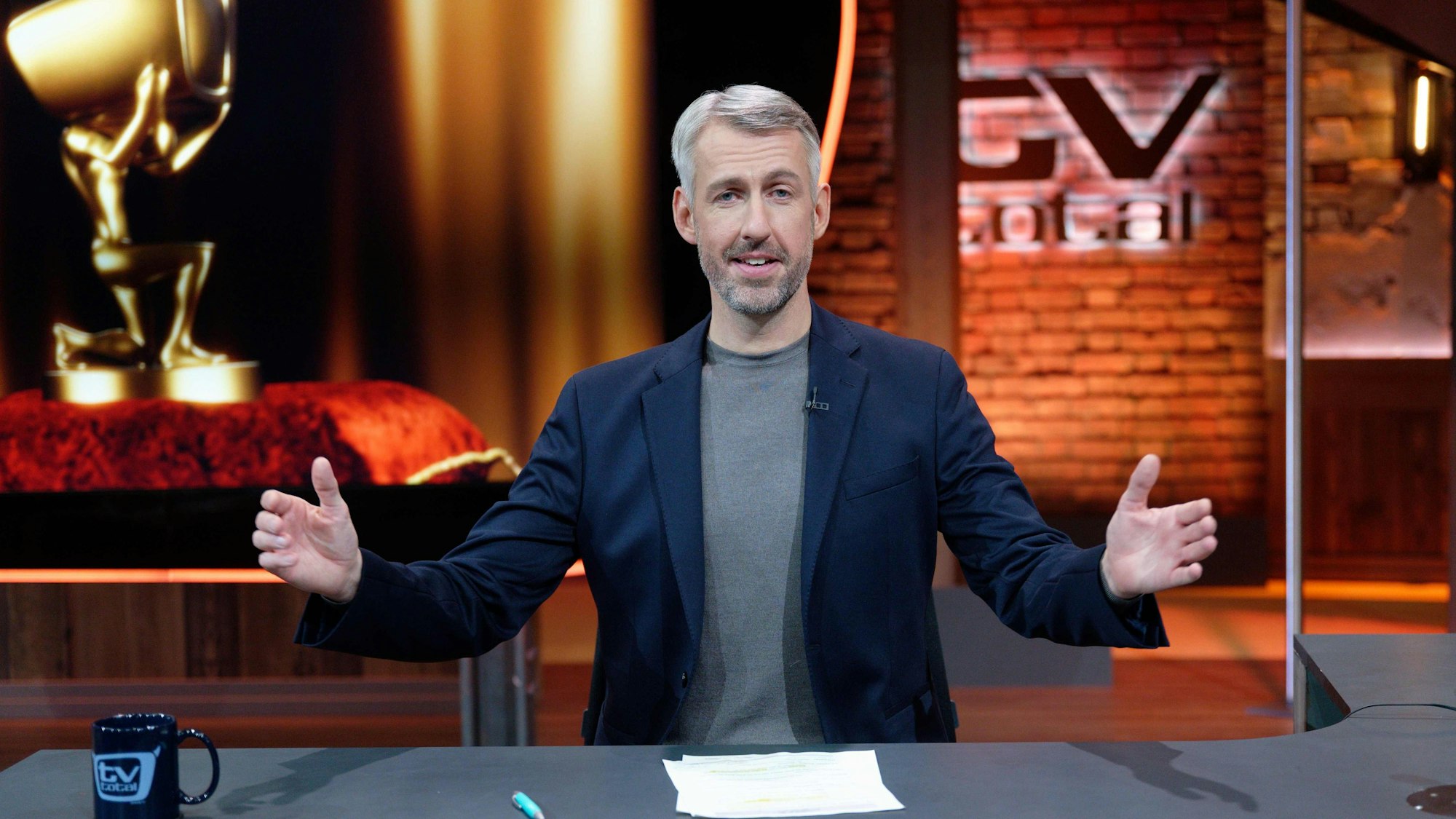 Sebastian Pufpaff sitzt am Moderationspult