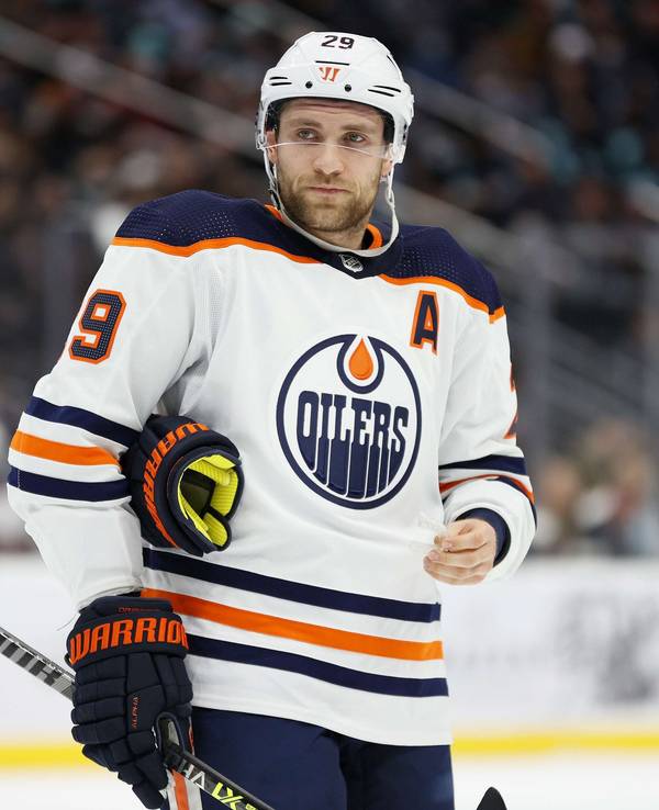 Leon Draisaitl steht auf dem Eis und hat sich gerade seinen linken Handschuh ausgezogen.