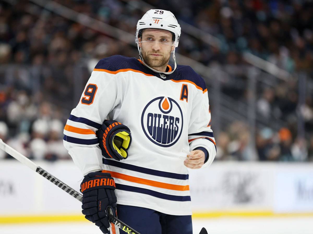 Leon Draisaitl steht auf dem Eis und hat sich gerade seinen linken Handschuh ausgezogen.