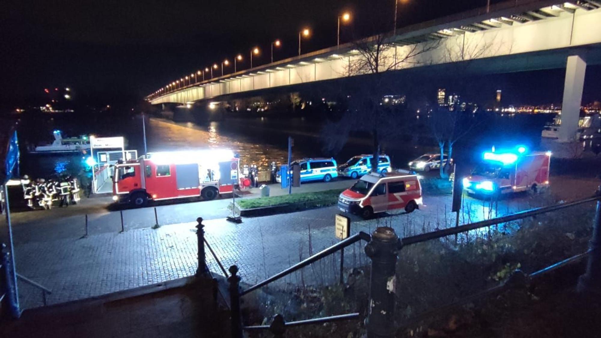 Polizei und Feuerwehr stehen am Rheinufer unter der Zoobrücke.