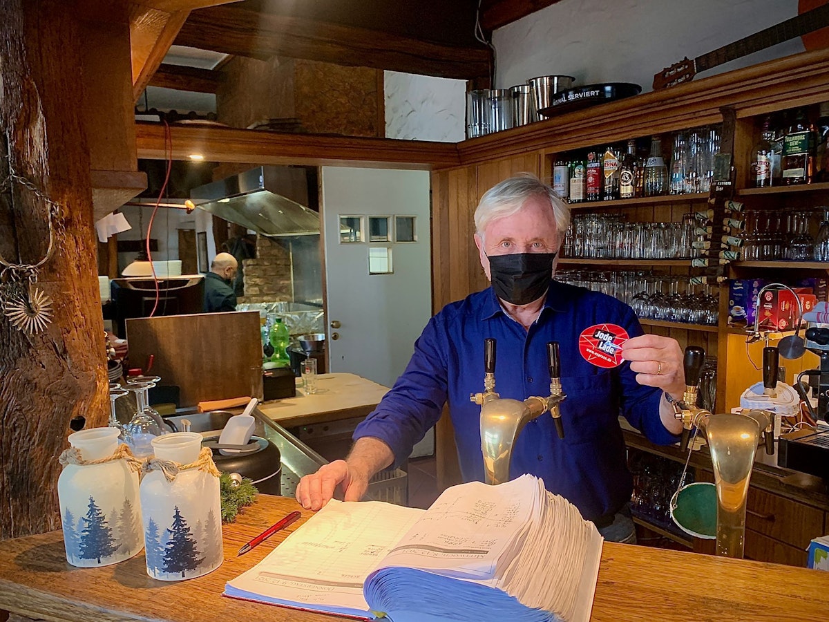 Casona Argentina-Betriebsleiter Guido Allmang hält das EXPRESS.de-Gütesiegel „Jode Lade“ in die Kamera.