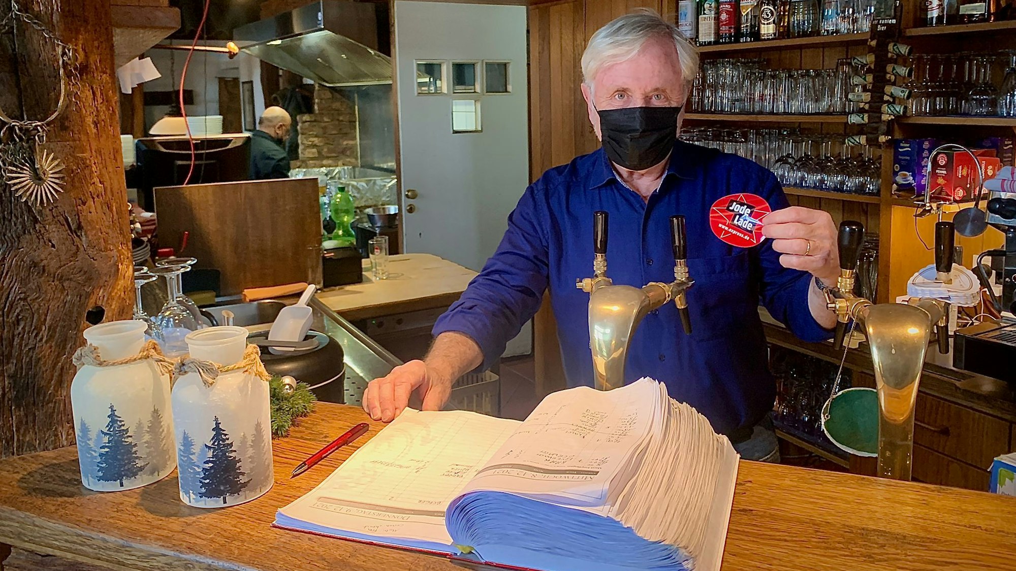 Casona Argentina-Betriebsleiter Guido Allmang hält das EXPRESS.de-Gütesiegel „Jode Lade“ in die Kamera.