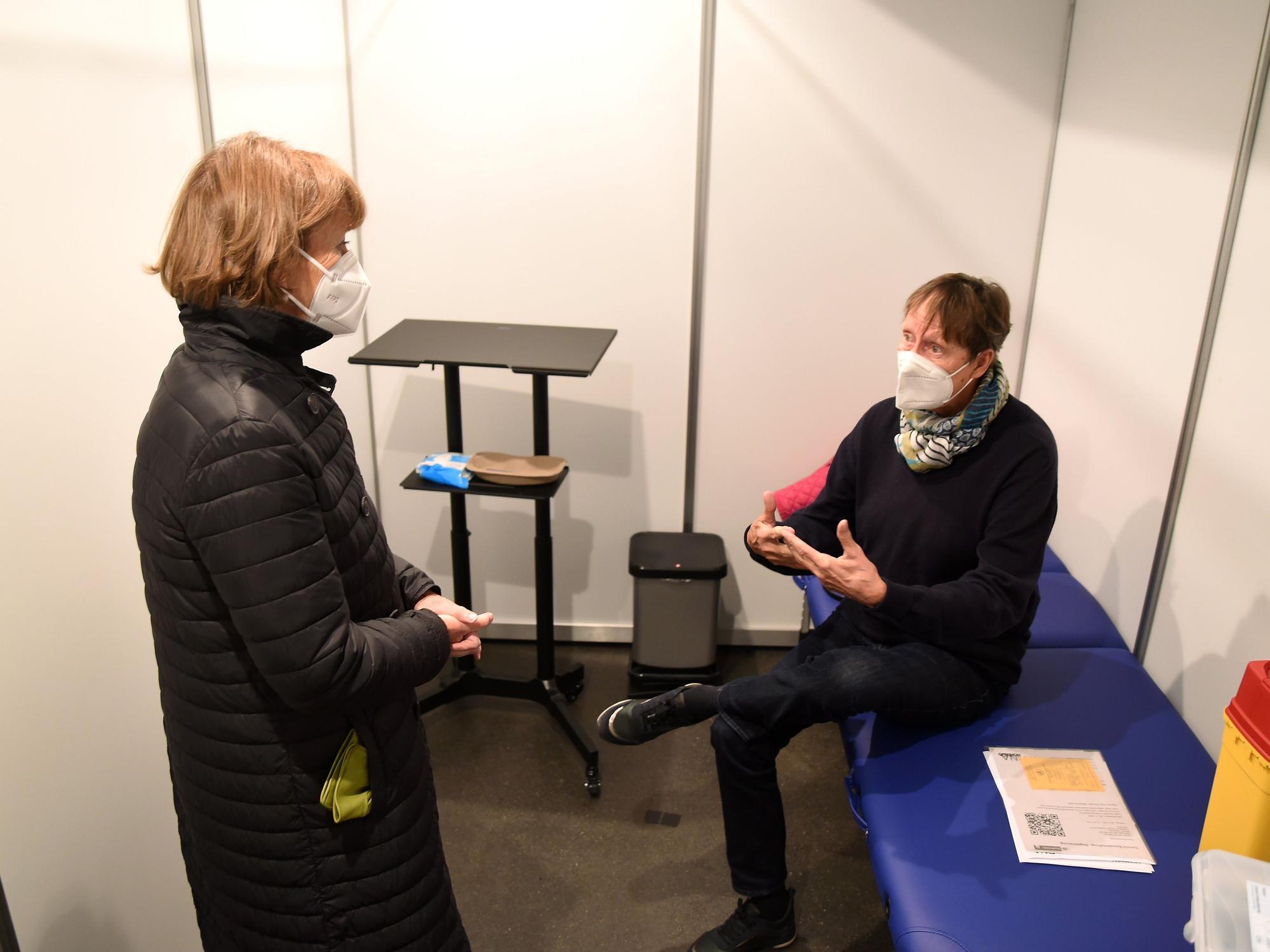 Henriette Reker mit einem Mann, der sich an der Lanxess Arena gegen Corona impfen ließ.