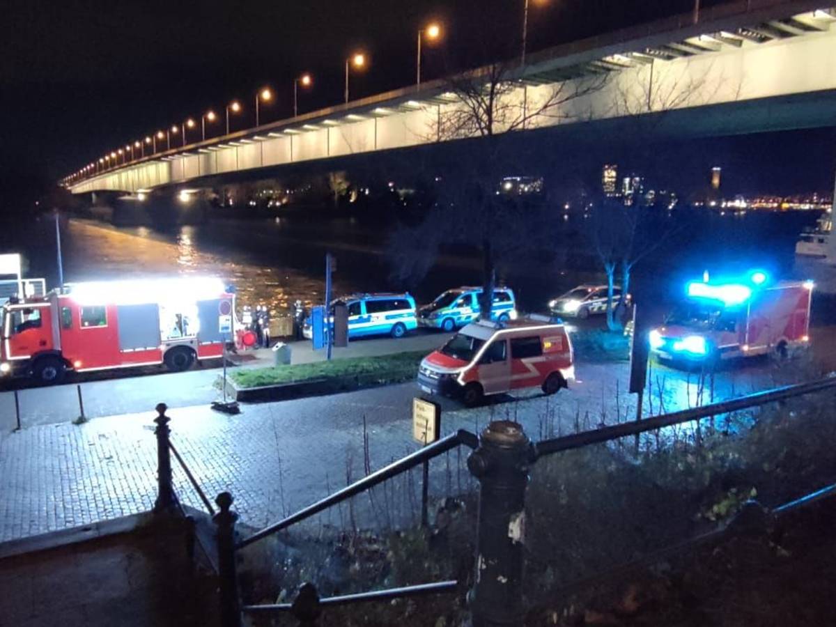 Polizei und Feuerwehr stehen am Rheinufer unter der Zoobrücke. Dort war ein Taxi in den Rhein gefahren.