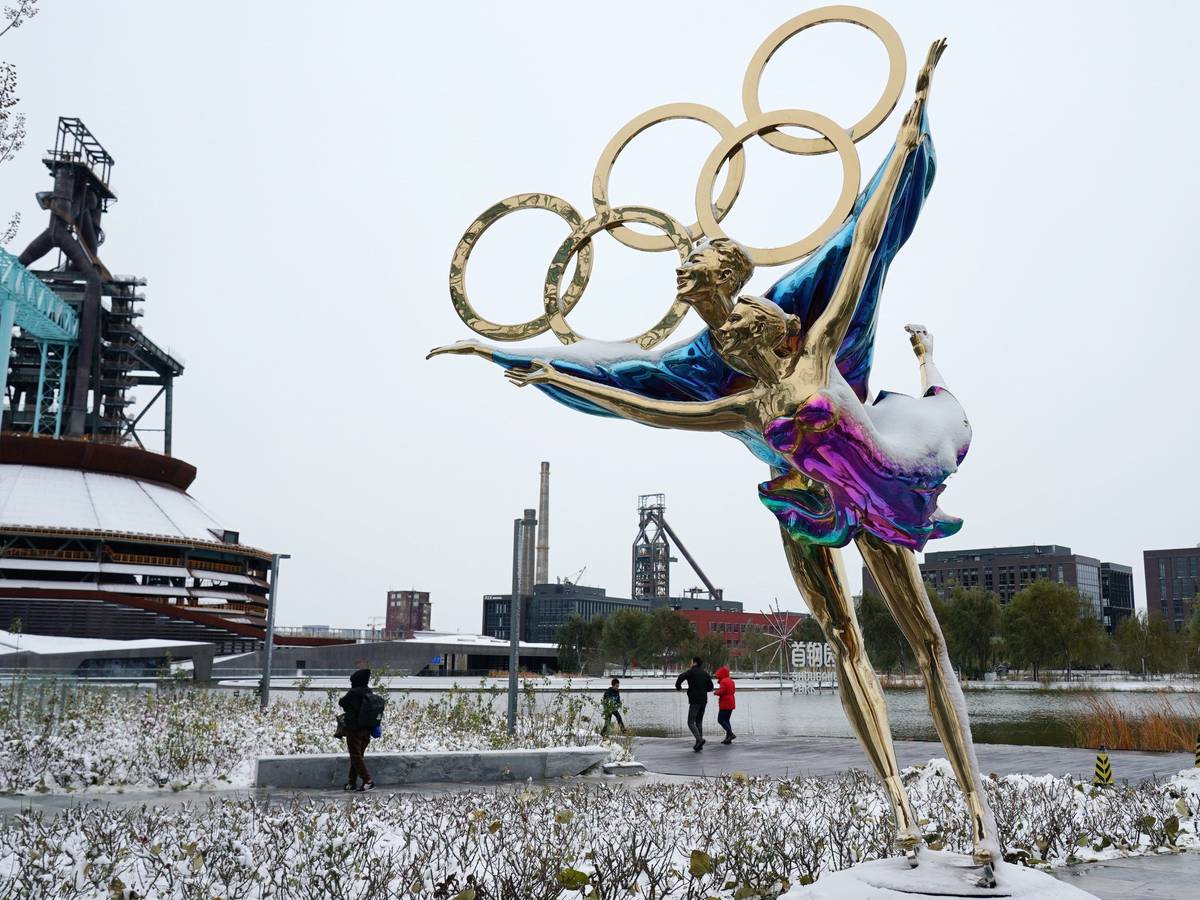 Eine Figur im Shougang-Park ist mit Schnee bedeckt. Winter-Olympia in China wird für die Organisatoren immer mehr zu Problemspielen.