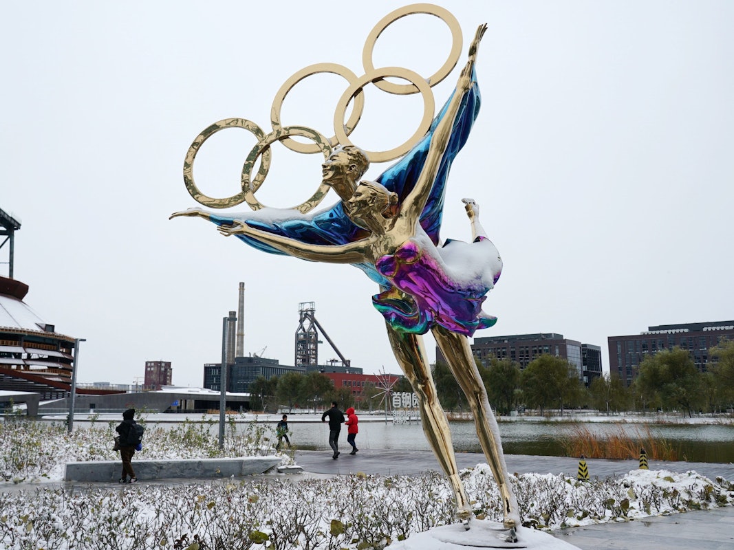 Eine Figur im Shougang-Park ist mit Schnee bedeckt. Winter-Olympia in China wird für die Organisatoren immer mehr zu Problemspielen.
