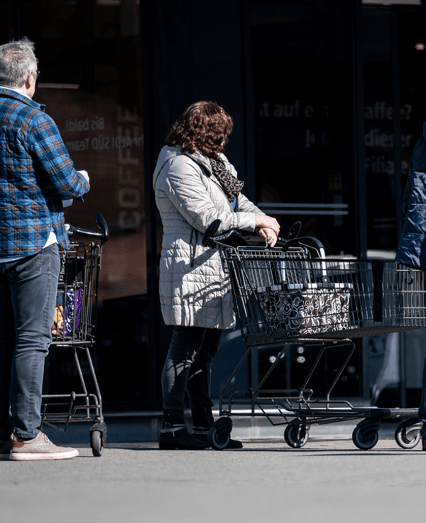 Menschen warten mit Abstand zueinander vor einer Filiale von Aldi Süd in Mülheim auf Einlass. Durch die Corona-Pandemie darf nur noch eine begrenzte Anzahl an Menschen gleichzeitig in den Markt.