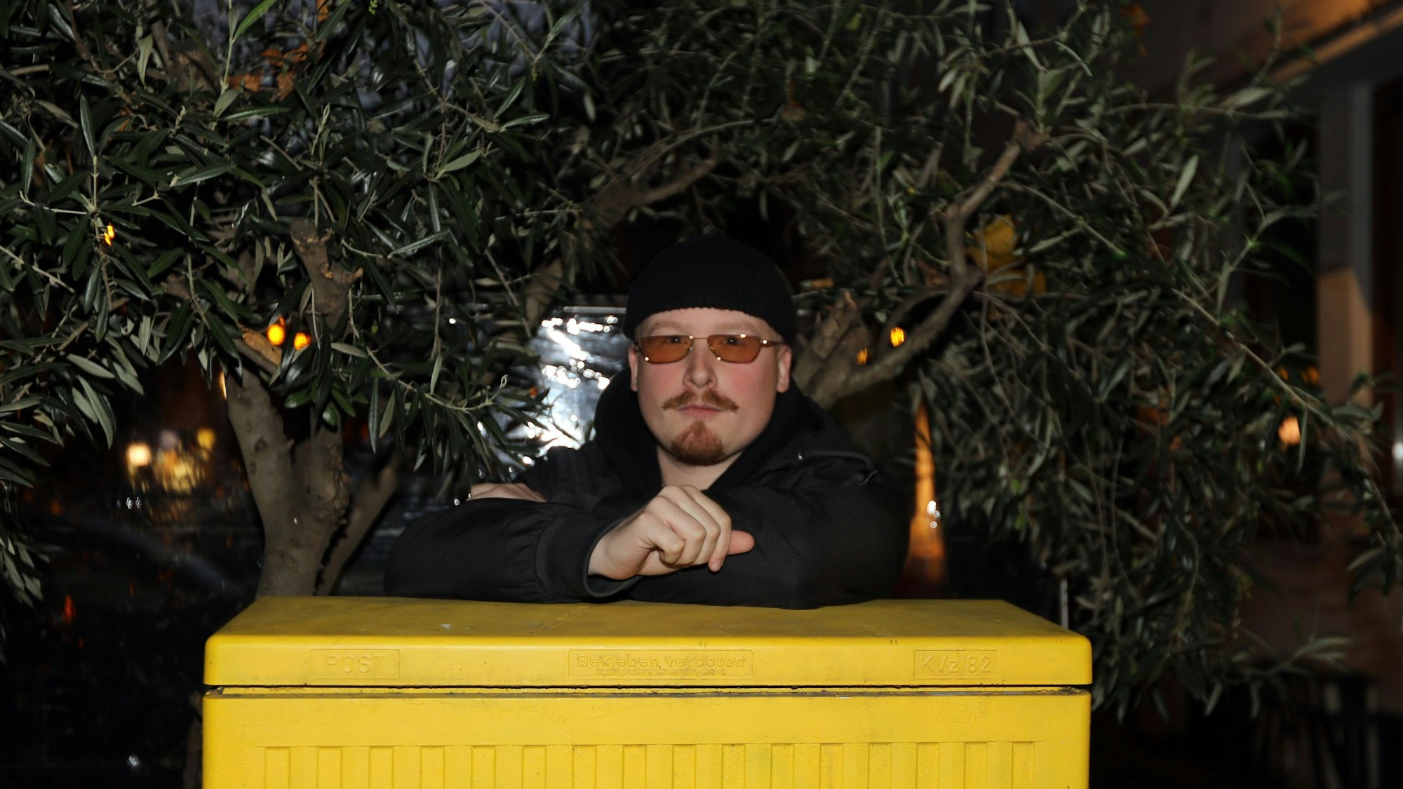 Art Garfunkel jr. lehnt auf einem gelben Stromkasten.