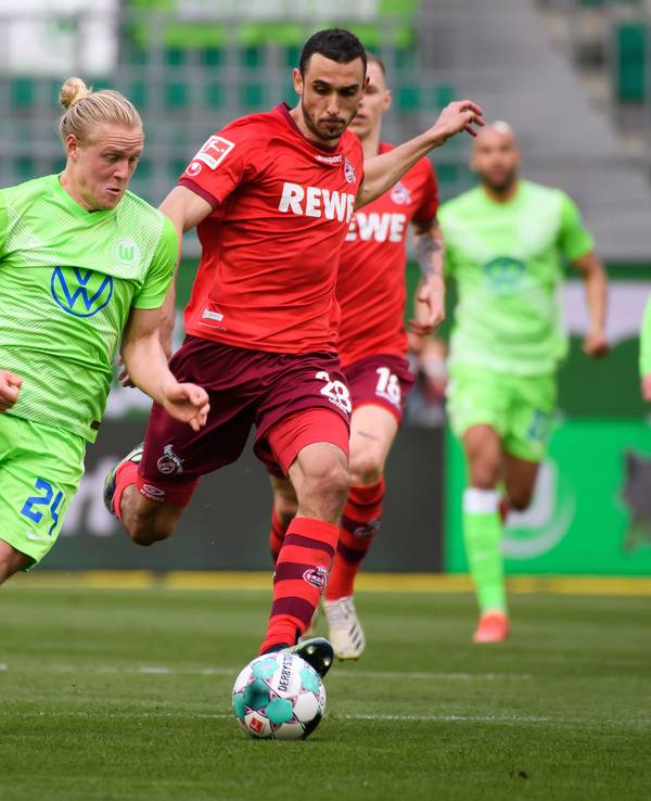 Wolfsburgs Xaver Schlager (l) spielt gegen Kölns Ellyes Skhiri.