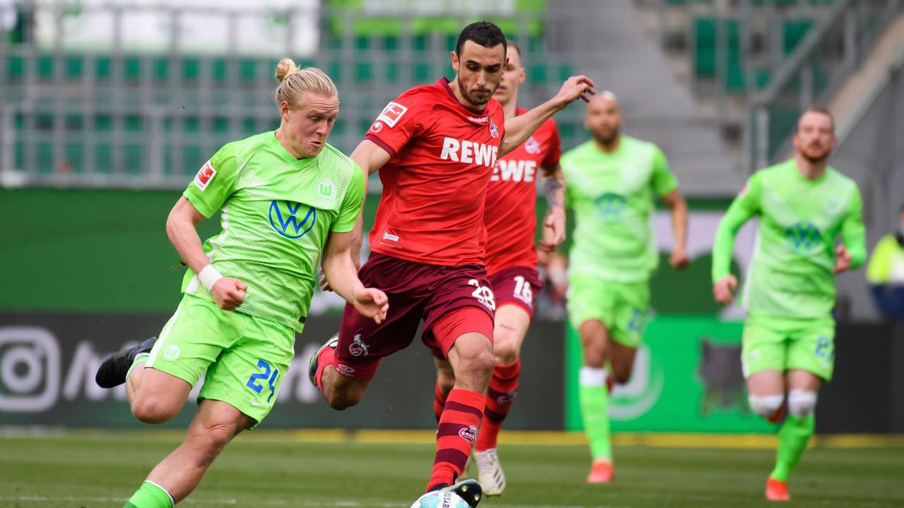 Wolfsburgs Xaver Schlager (l) spielt gegen Kölns Ellyes Skhiri.