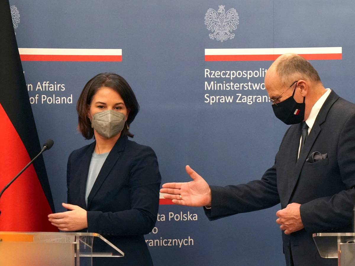 Außenministerin Annalena Baerbock (l.) wir von ihrem polnischen Amtskollegen Zbigniew Rau ans Rednerpult geführt.