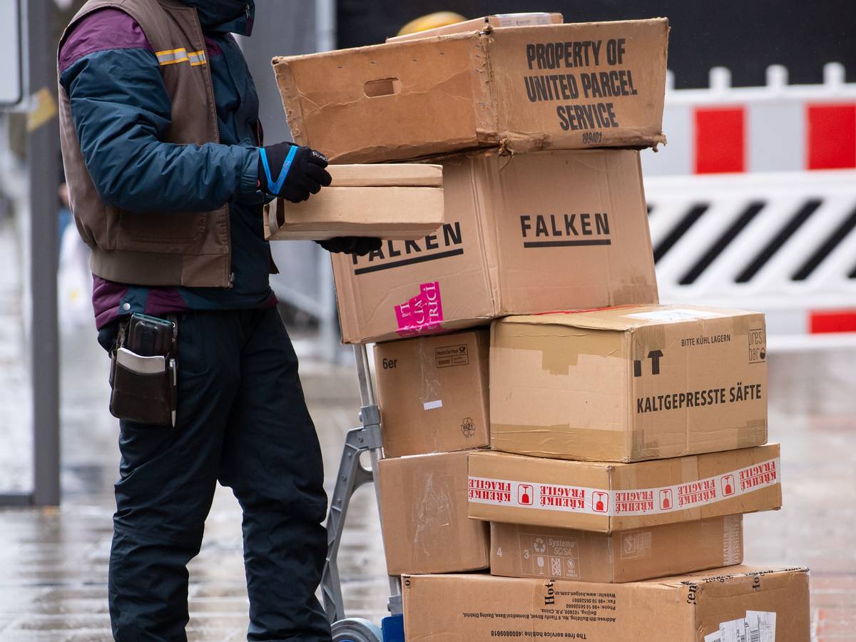 Ein Paketbote liefert in der Innenstadt seine Pakete aus.