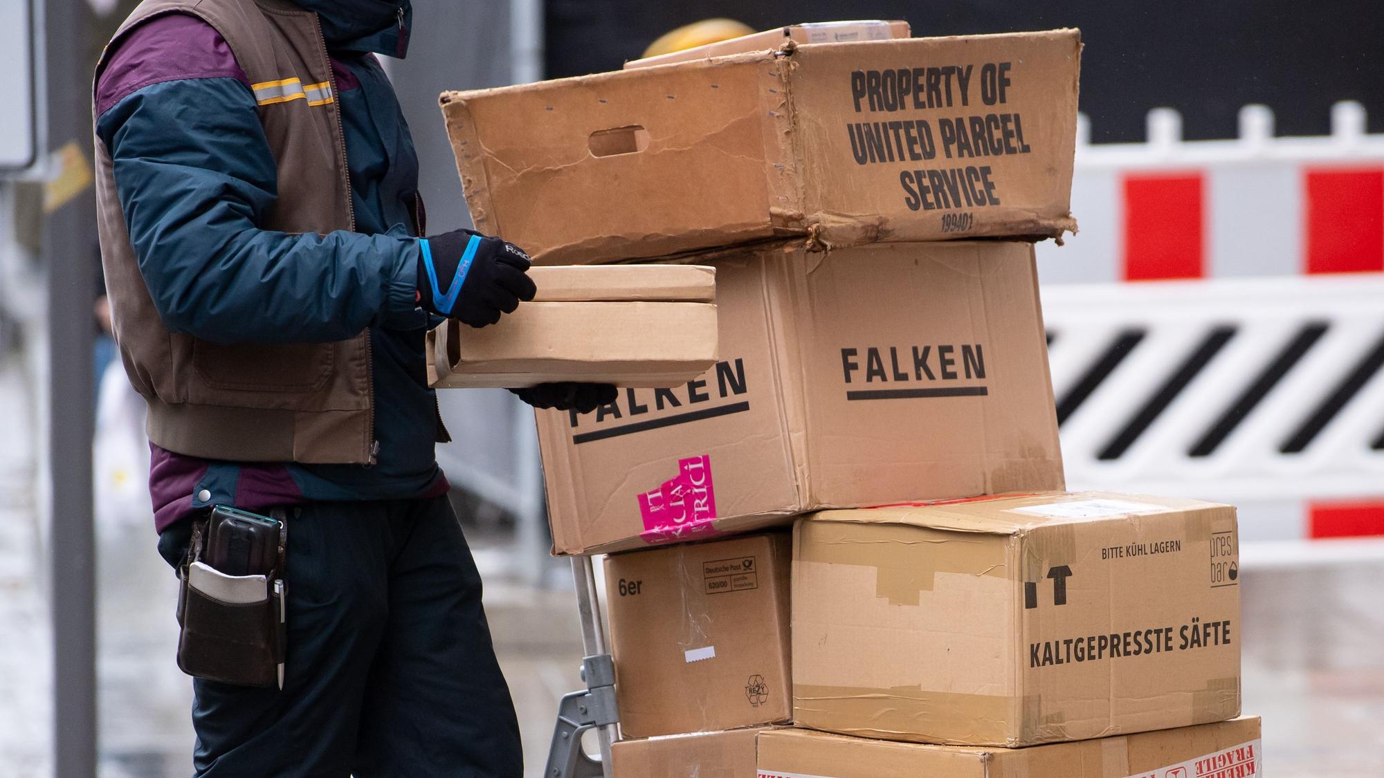 Ein Paketbote liefert in der Innenstadt seine Pakete aus.