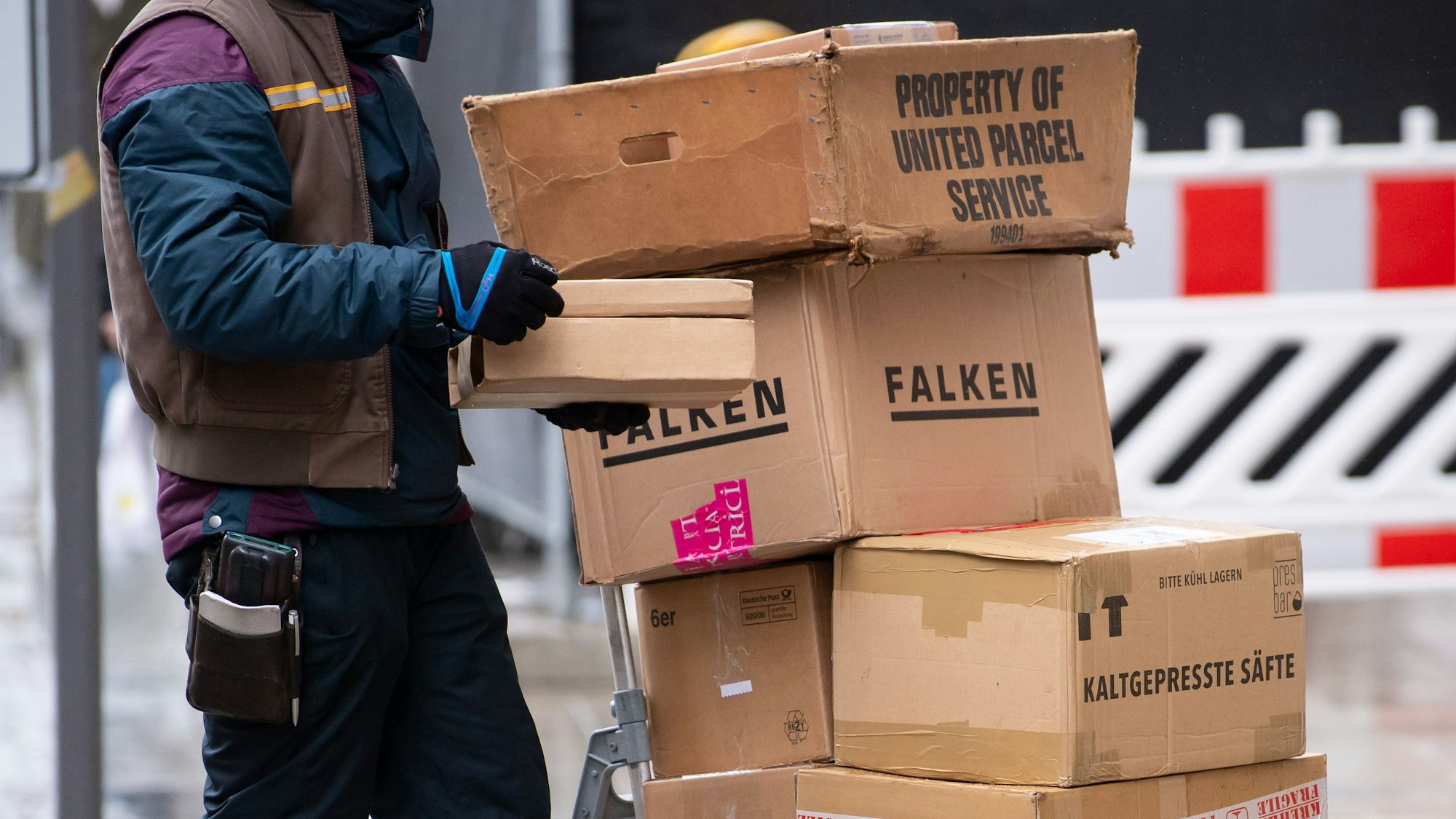 Ein Paketbote liefert in der Innenstadt seine Pakete aus.