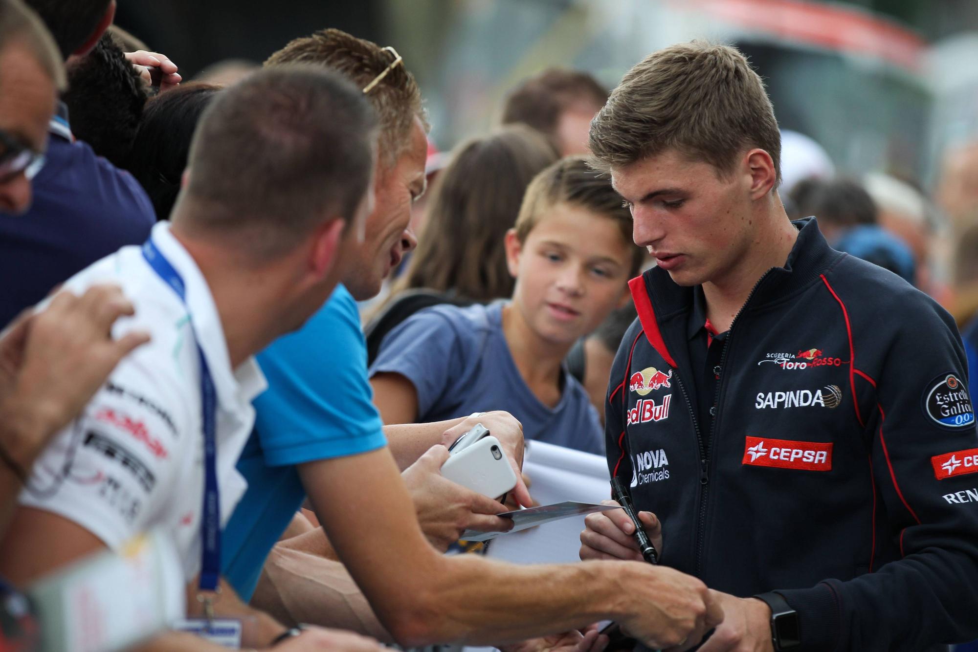 Der junge Max Verstappen schreibt Autogramme.