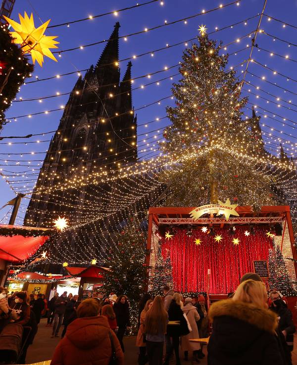 Besucher gehen über den Weihnachtsmarkt auf dem Roncalliplatz am Kölner Dom.